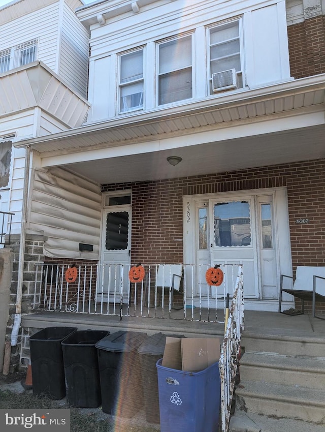 5302 Akron St, Philadelphia, PA 19124 - property entrance featuring a porch, brick siding, and cooling unit