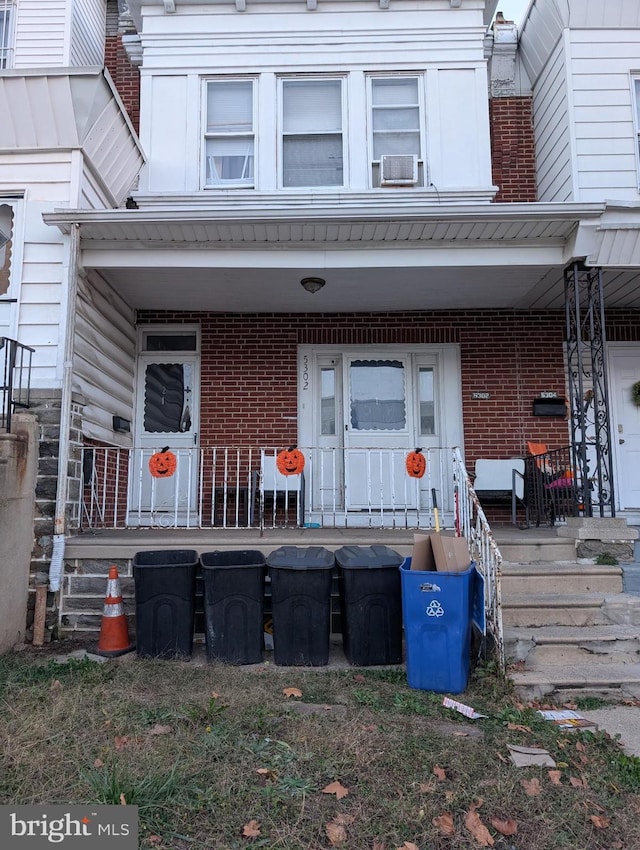 5302 Akron St, Philadelphia, PA 19124 - doorway to property featuring a porch, brick siding, and cooling unit