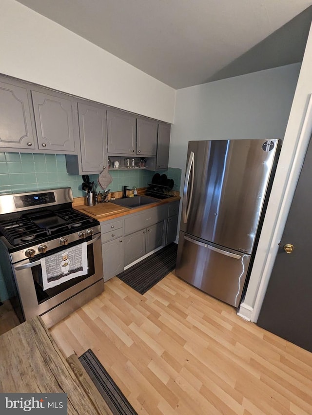 5302 Akron St, Philadelphia, PA 19124 - kitchen with stainless steel appliances, gray cabinetry, decorative backsplash, and light wood-type flooring