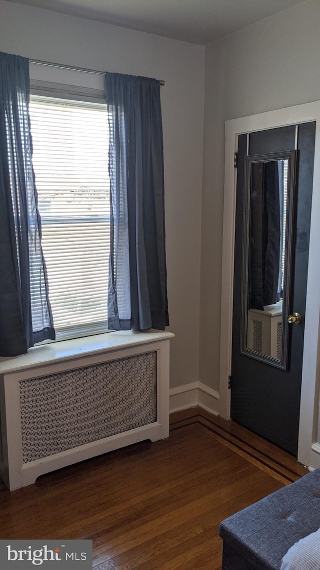 foyer with radiator and dark wood-type flooring