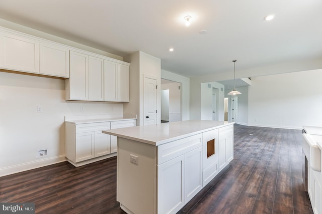 kitchen featuring white cabinetry, dark hardwood / wood-style flooring, and hanging light fixtures