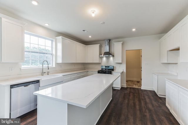 kitchen with black gas range, wall chimney exhaust hood, dark wood-type flooring, stainless steel dishwasher, and a kitchen island