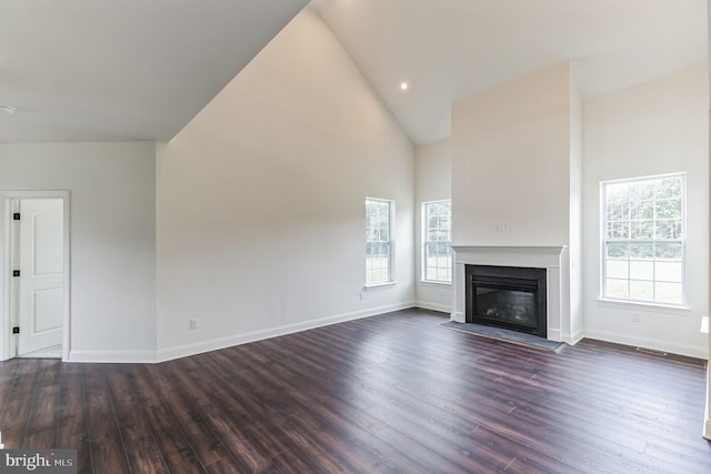 unfurnished living room featuring dark wood-type flooring and a healthy amount of sunlight