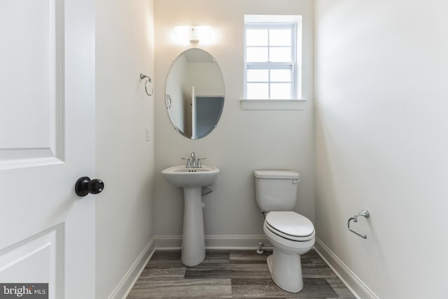 bathroom featuring wood-type flooring and toilet