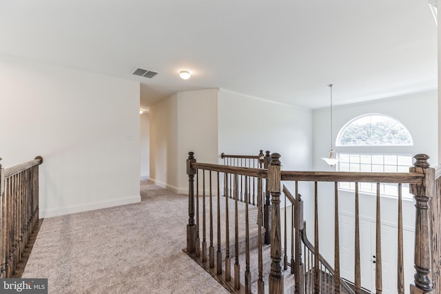 hallway featuring light colored carpet