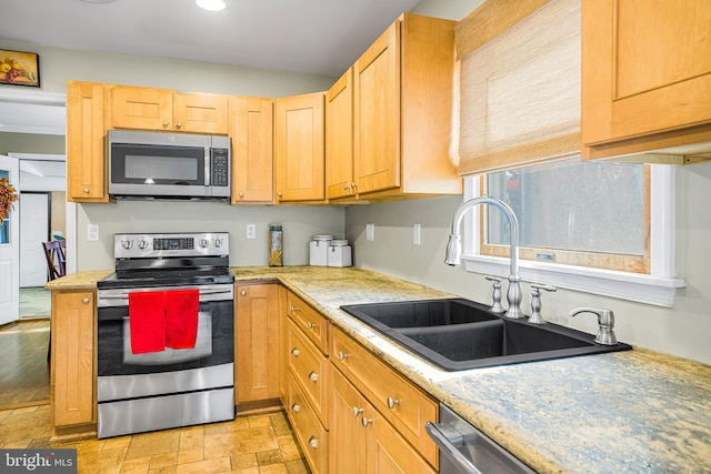 kitchen with light brown cabinets, stainless steel appliances, and sink