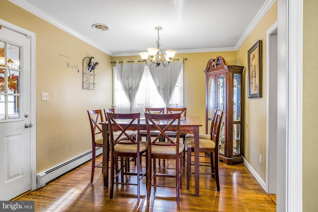 dining room with plenty of natural light, wood-type flooring, and a baseboard heating unit