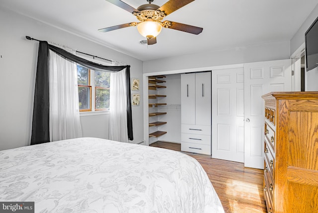 bedroom featuring hardwood / wood-style floors, ceiling fan, and a closet