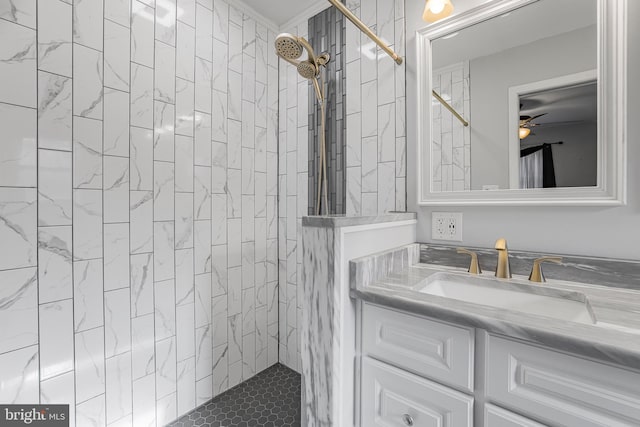 bathroom featuring tiled shower and vanity