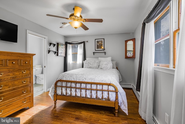 bedroom featuring dark hardwood / wood-style floors, ceiling fan, ensuite bathroom, and a baseboard heating unit