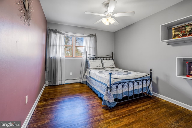 bedroom featuring ceiling fan, dark wood-type flooring, and a baseboard heating unit