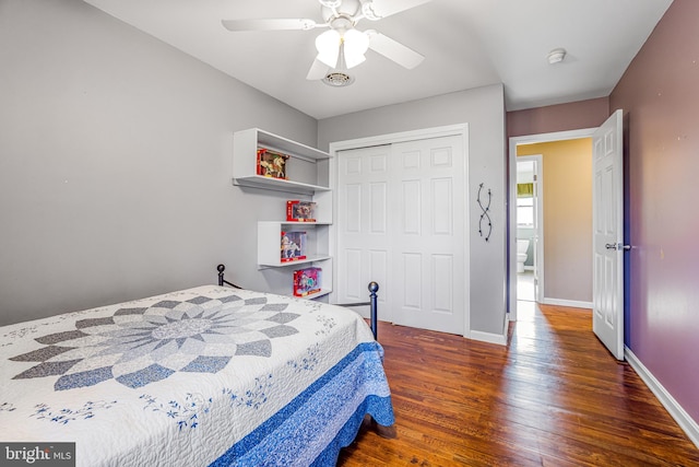 bedroom with dark hardwood / wood-style flooring, a closet, and ceiling fan