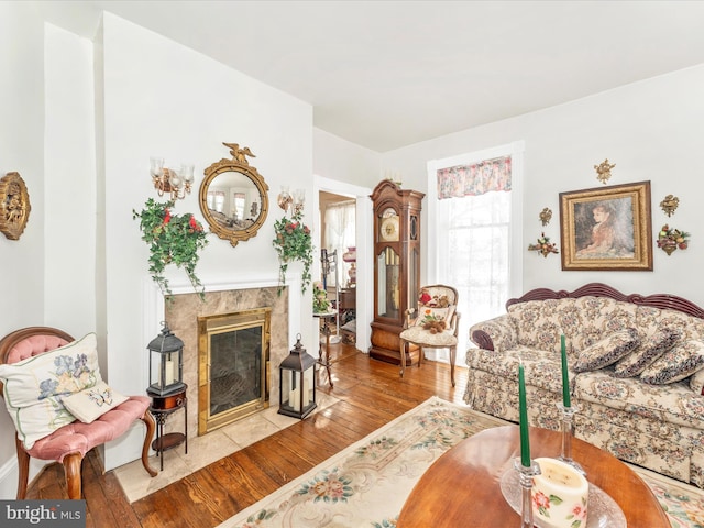 living room featuring a high end fireplace and light wood-type flooring