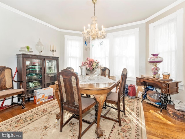 dining room featuring hardwood / wood-style flooring, crown molding, and a notable chandelier