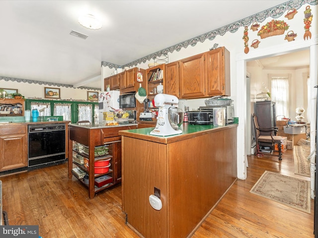 kitchen featuring a center island, light wood-type flooring, and black appliances