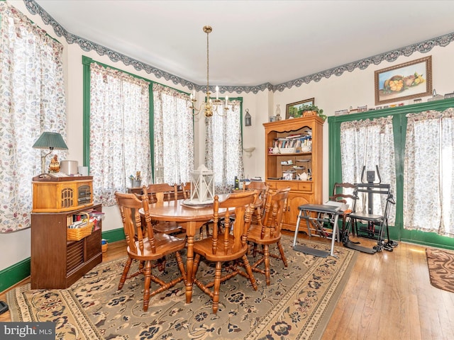 dining area with plenty of natural light, hardwood / wood-style floors, and a chandelier