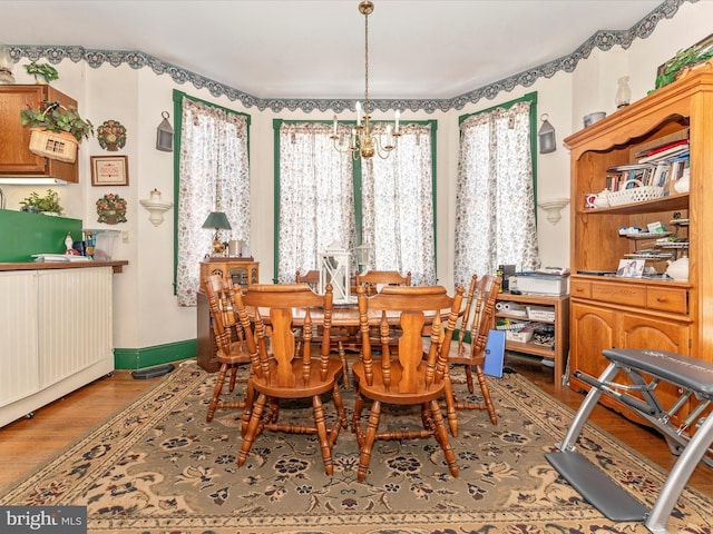 dining room with hardwood / wood-style floors and a chandelier