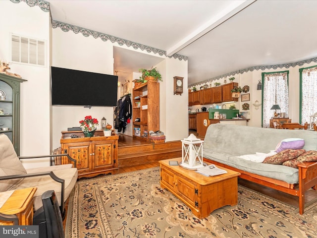 living room featuring light hardwood / wood-style flooring and beamed ceiling