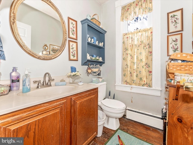 bathroom featuring hardwood / wood-style flooring, vanity, toilet, and a baseboard heating unit