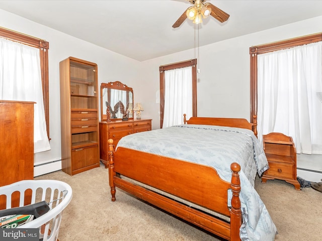 bedroom with a baseboard radiator, light colored carpet, and ceiling fan