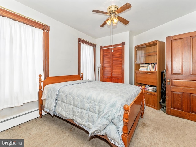 bedroom with baseboard heating, ceiling fan, and light colored carpet