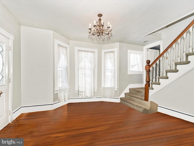 entrance foyer featuring hardwood / wood-style flooring and a notable chandelier