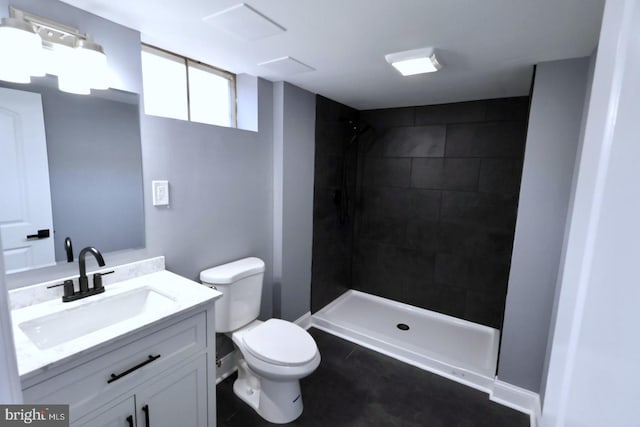 bathroom with tiled shower, tile patterned floors, vanity, and toilet