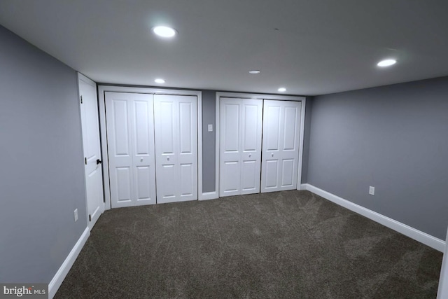 unfurnished bedroom featuring carpet floors and two closets