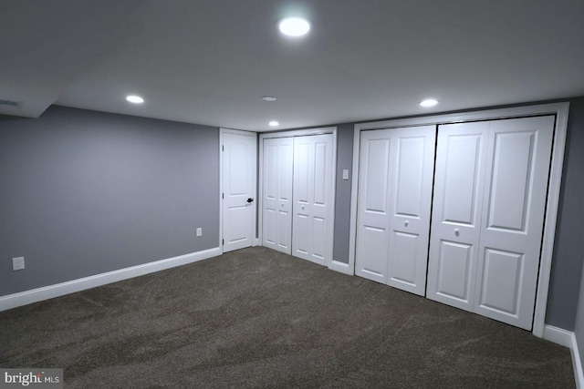 unfurnished bedroom with two closets and dark carpet