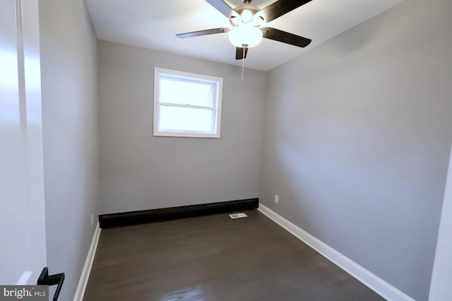 unfurnished room with dark hardwood / wood-style floors and ceiling fan