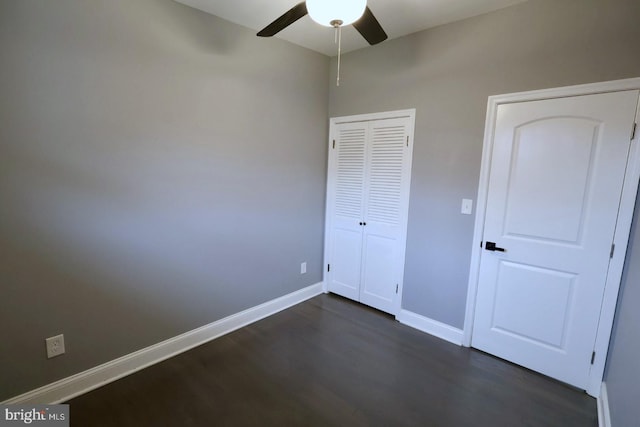 unfurnished bedroom with ceiling fan and dark wood-type flooring