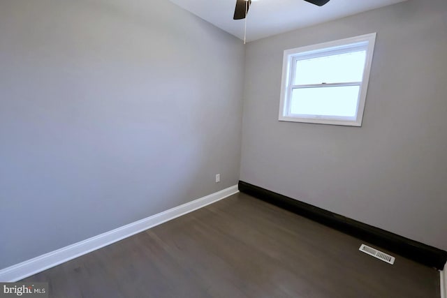 empty room with ceiling fan and dark hardwood / wood-style floors