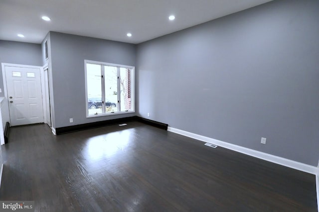 unfurnished room featuring dark wood-type flooring