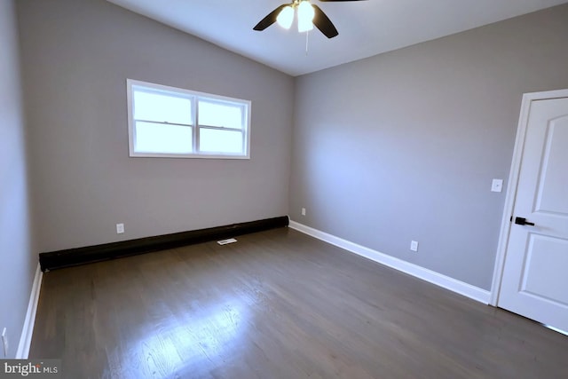 unfurnished room featuring ceiling fan, dark hardwood / wood-style flooring, and vaulted ceiling