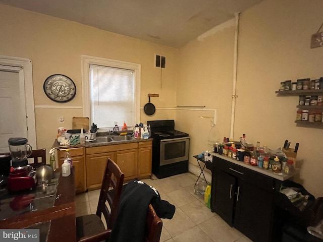 kitchen featuring light tile patterned floors, black range with electric stovetop, and sink