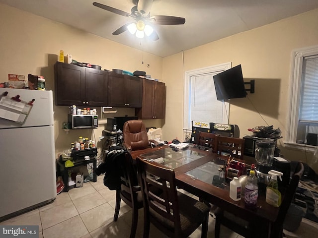 kitchen featuring dark brown cabinetry, white fridge, ceiling fan, and light tile patterned flooring