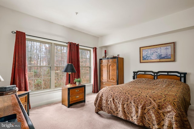 bedroom with light colored carpet and multiple windows