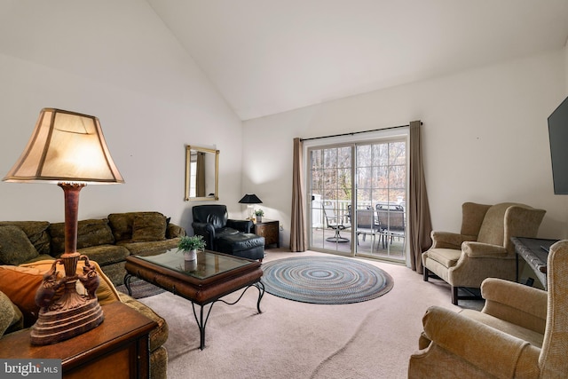 carpeted living room with high vaulted ceiling