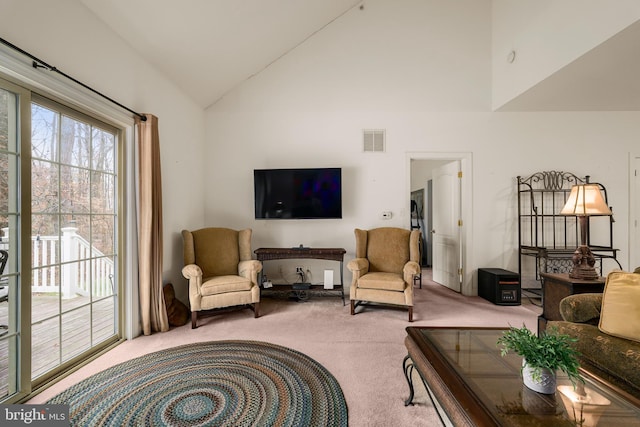 carpeted living room featuring high vaulted ceiling