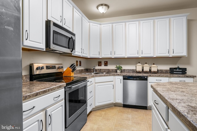 kitchen with white cabinets, appliances with stainless steel finishes, and sink