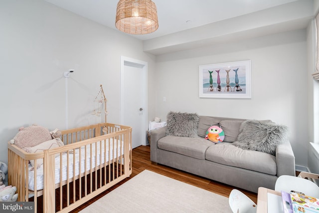 bedroom featuring a crib and wood-type flooring