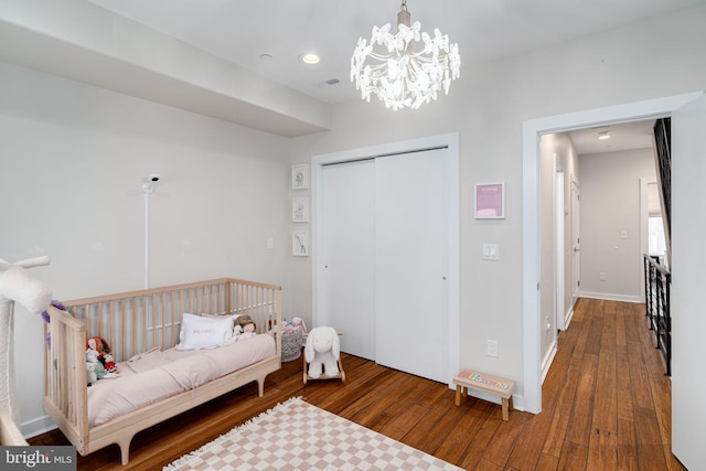 bedroom featuring hardwood / wood-style floors, a closet, and a notable chandelier