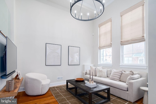 living room featuring a notable chandelier, dark hardwood / wood-style floors, and a high ceiling