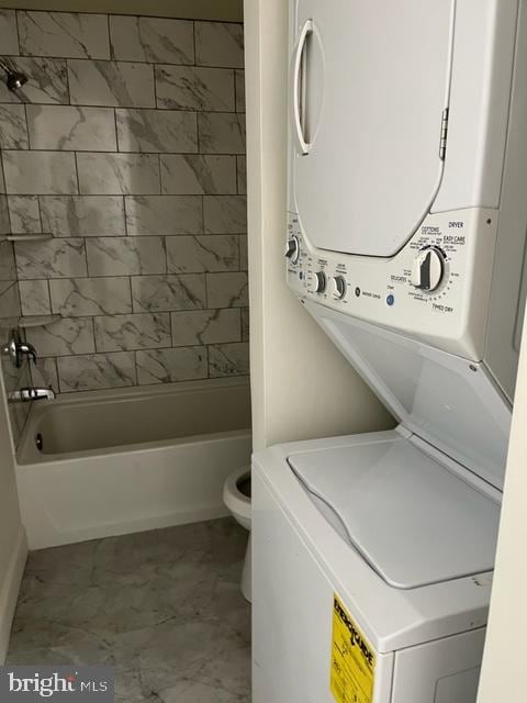 clothes washing area featuring stacked washer and dryer