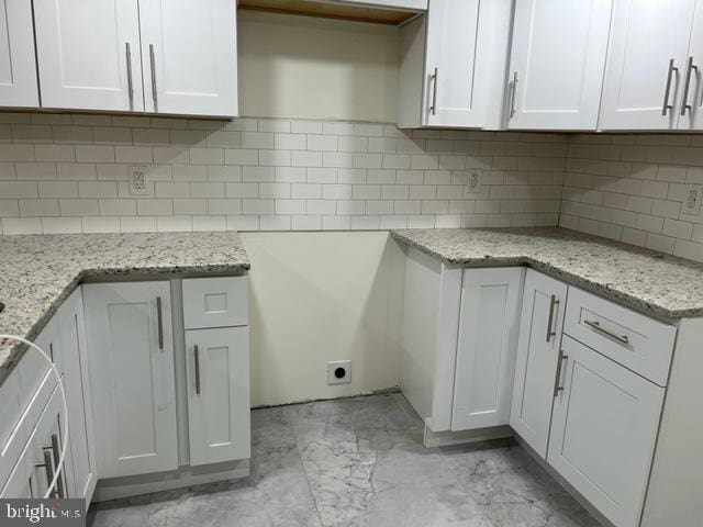 kitchen featuring white cabinets and decorative backsplash