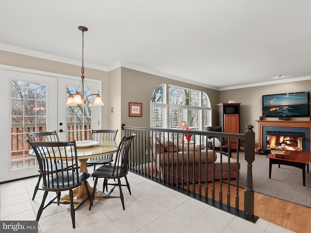 dining room with light wood-type flooring, ornamental molding, and a wealth of natural light