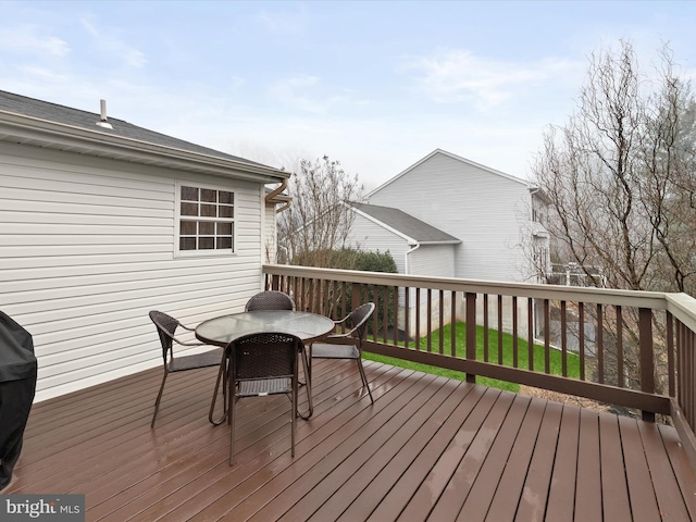 wooden deck featuring a lawn