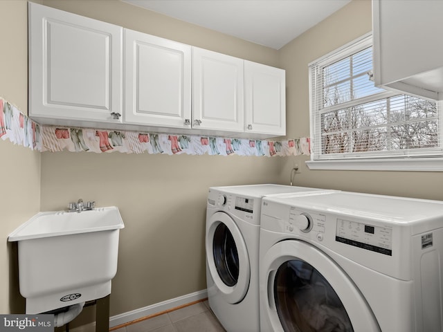 laundry area featuring washer and dryer, sink, light tile patterned floors, and cabinets