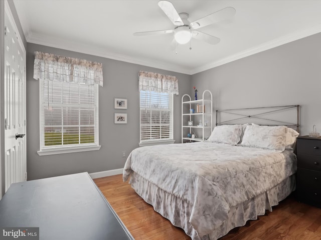 bedroom featuring hardwood / wood-style floors, ceiling fan, and crown molding