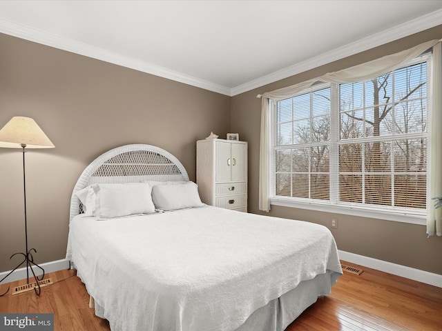 bedroom featuring hardwood / wood-style floors and crown molding